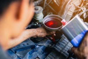 Pouring new transmission fluid into a car in Chicago, Illinois